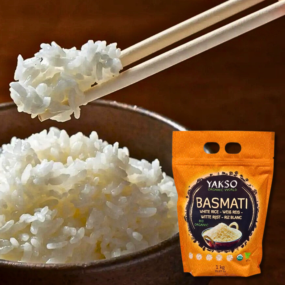 Close-up of fluffy basmati rice held by chopsticks above a bowl, with a Yakso Basmati Rice 1 kg package in the foreground.